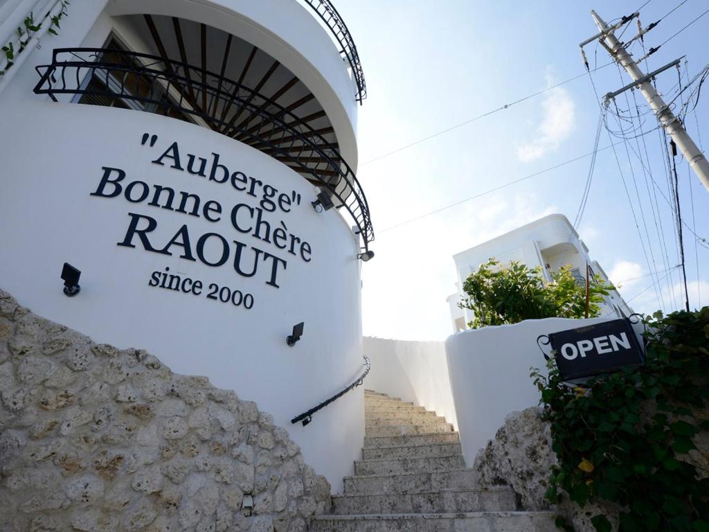 una señal en el lateral de un edificio con escaleras en Auberge Bonne Chere Raout en Onna