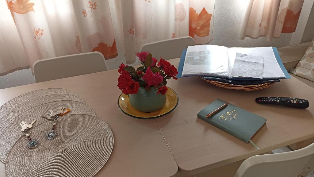 une table avec un vase de fleurs et un livre dans l'établissement Casa Liébana, à Torrox