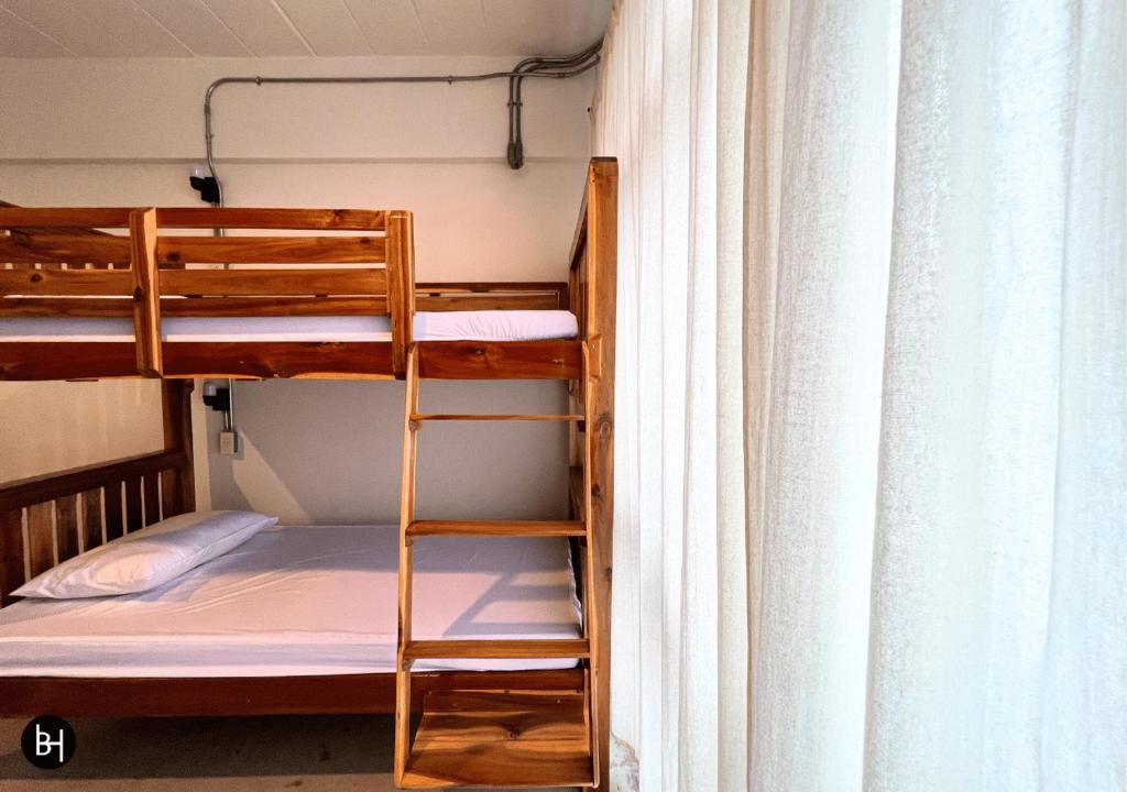 a bunk bed with a ladder next to a window at BAAN650 Hostel in Ban Kohong