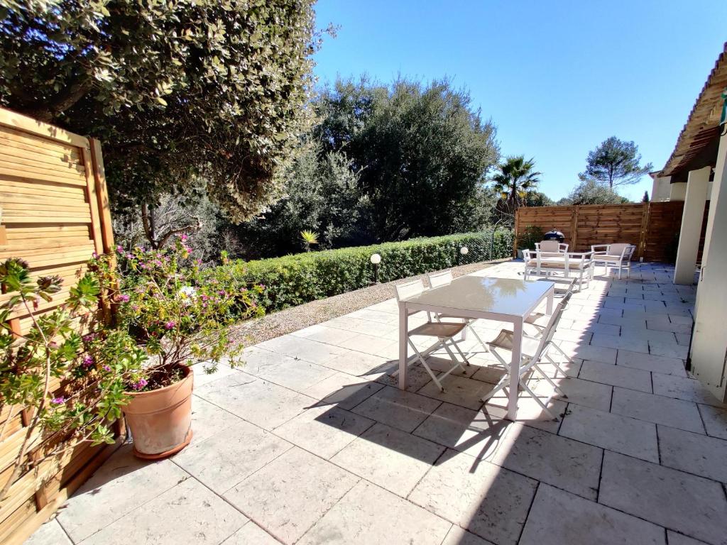 een witte tafel en stoelen op een patio bij Bas de villa indépendant. 10min de la mer in Biot