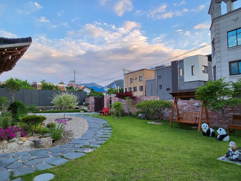 un jardín con una pasarela de piedra en un patio en Moon Drawing Goeun, en Chuncheon