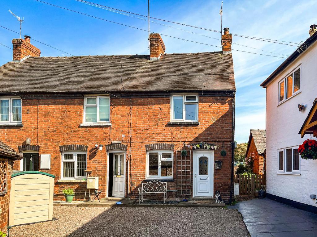 a red brick house with a white door at Star Yard in Tenbury