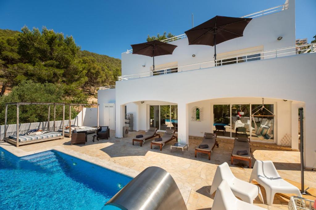 a villa with a swimming pool and a house at Villa Amarantos in Santa Eularia des Riu