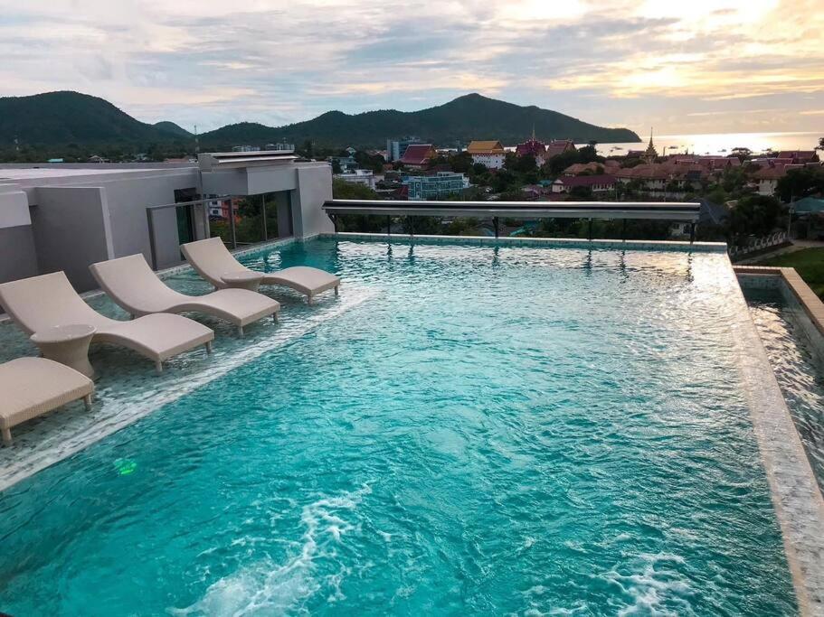 a pool on the roof of a building with chairs at Lovely condo with swimming pool. in Bang Sare