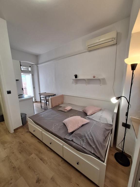 a bedroom with a bed with pink pillows on it at Apartma Koper2 with parking in Koper