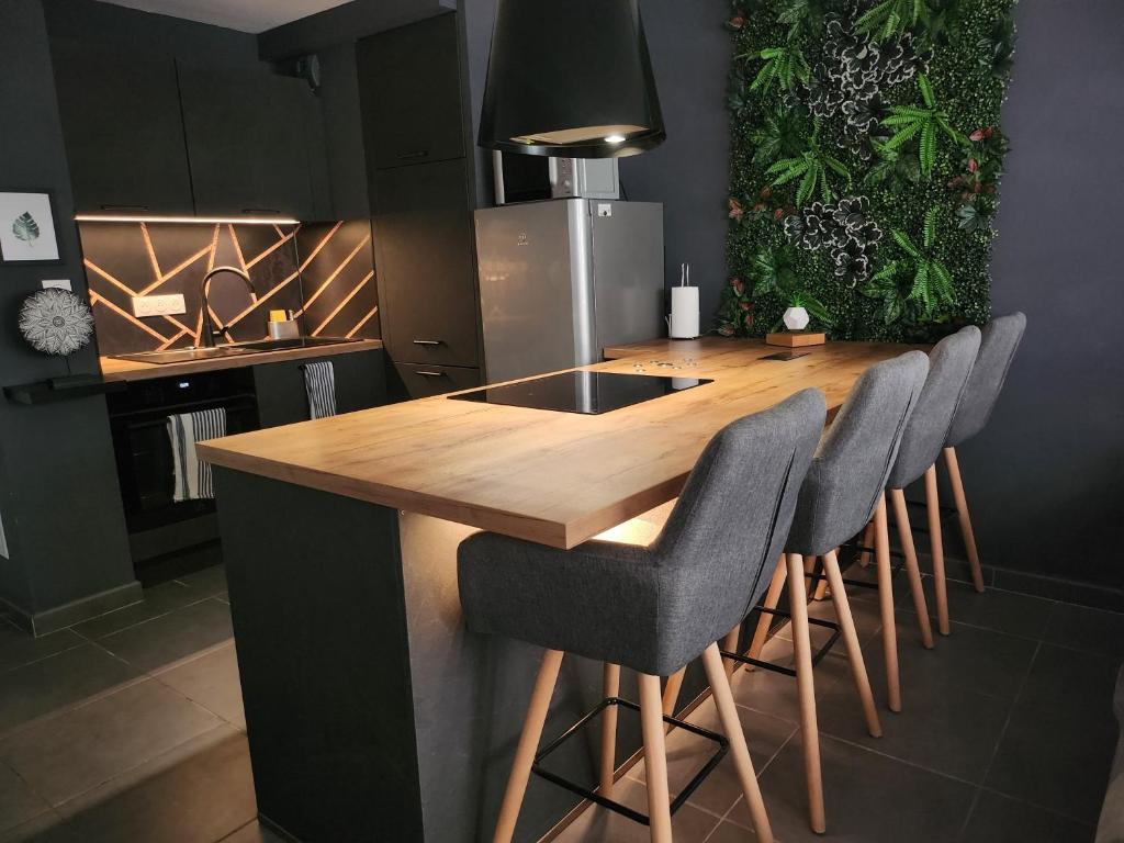 une cuisine avec un comptoir en bois entouré de chaises dans l'établissement Proche Avignon centre, jardin & climatisation 4pers, à Avignon