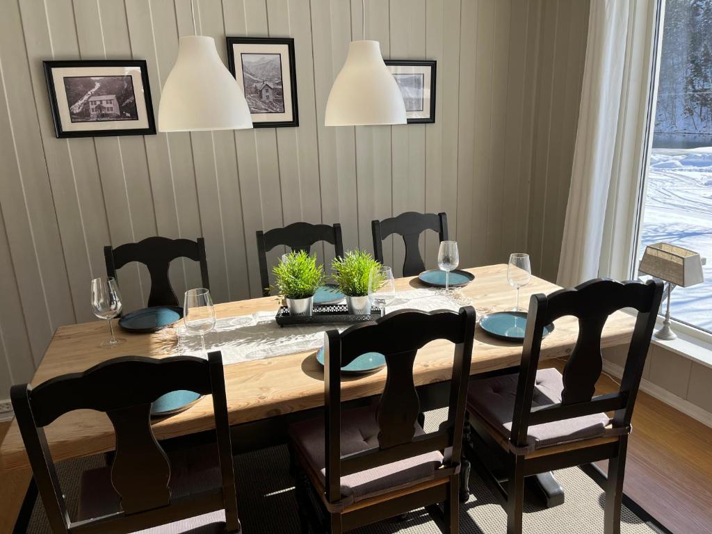 stół jadalny z krzesłami i drewniany stół z roślinami w obiekcie Trolltunga Lodge w mieście Odda
