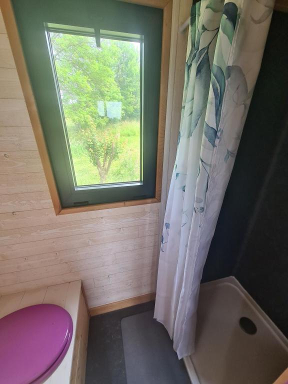 a small bathroom with a toilet and a window at Camping à la ferme - Hébergements insolites in Cerisy-la-Forêt