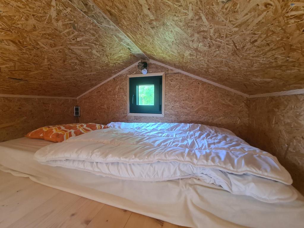 a large bed in a room with a window at Camping à la ferme - Hébergements insolites in Cerisy-la-Forêt
