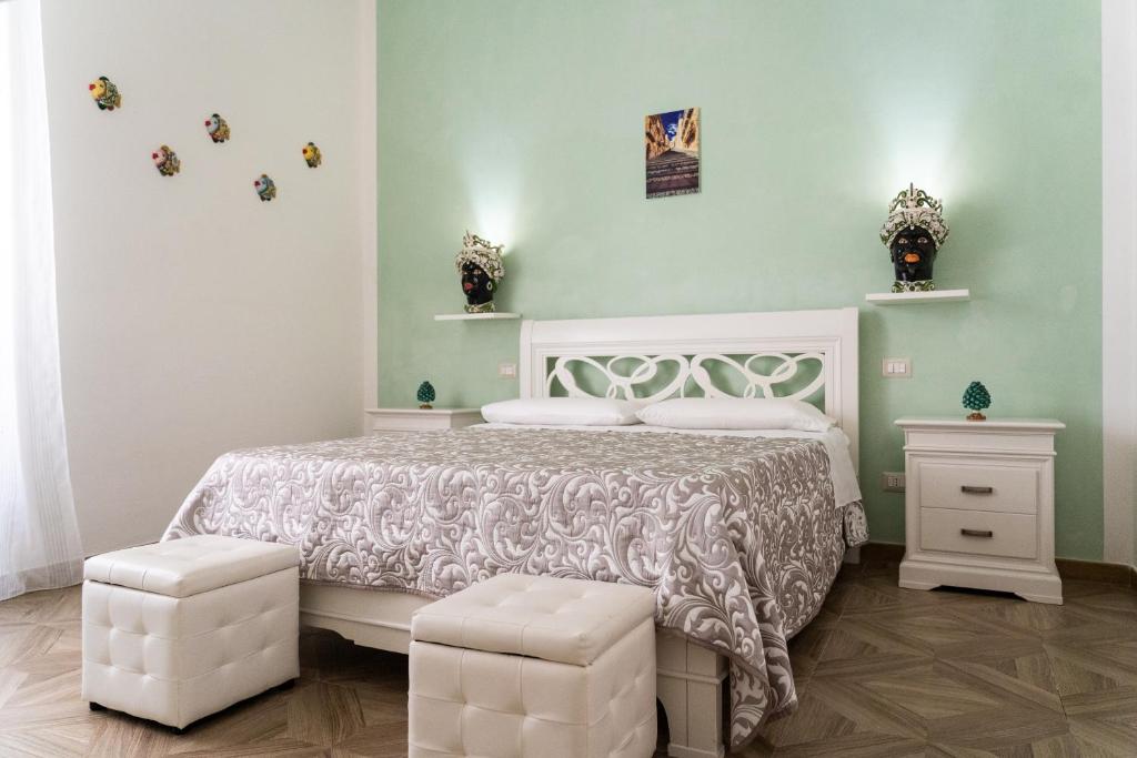 1 dormitorio con 1 cama blanca y 2 taburetes blancos en B&B Portosalvo en Santa Teresa di Riva