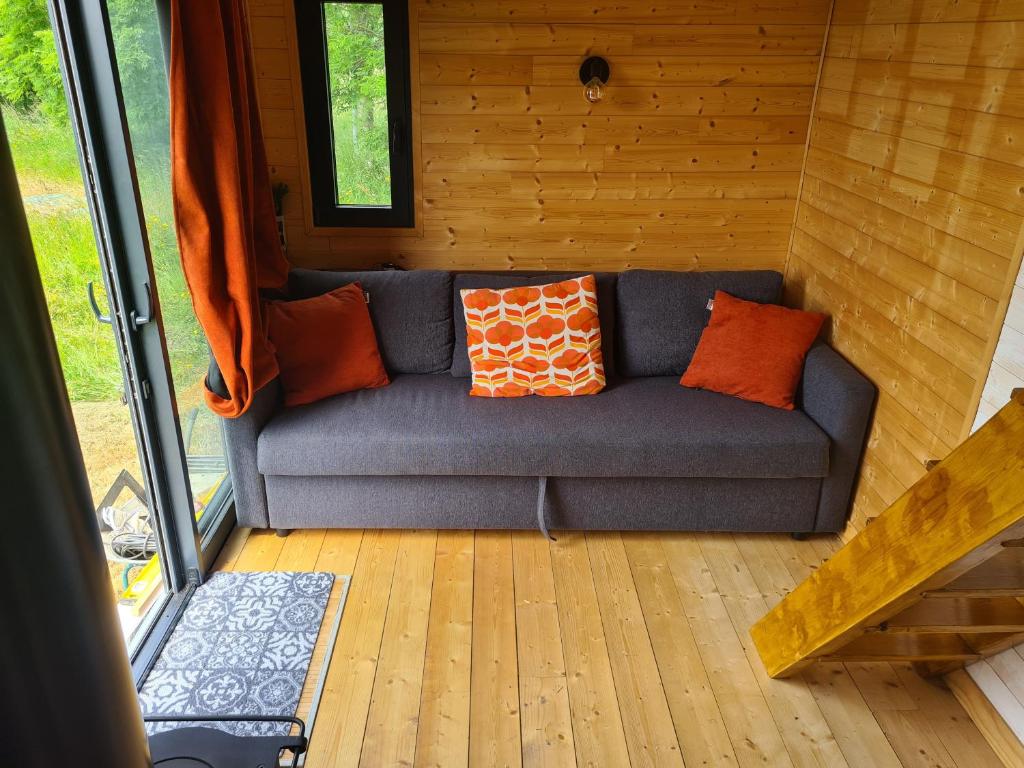 a blue couch with pillows sitting in a room at Camping à la ferme - Hébergements insolites in Cerisy-la-Forêt