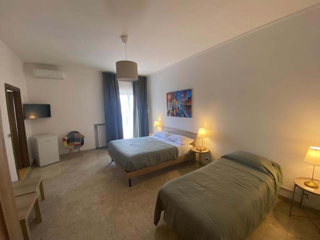 1 dormitorio con 2 camas y 2 lámparas en affittacamere San Michele en Taranto