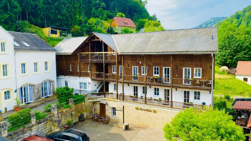 ein großes Holzgebäude in einer Stadt mit Bäumen in der Unterkunft Apartments Erbgericht in Bad Schandau