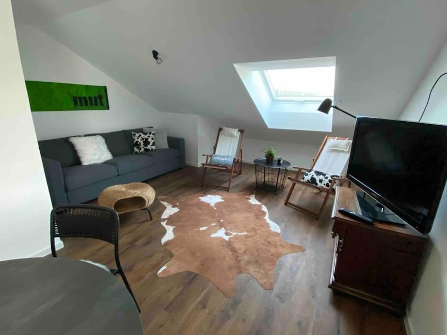 a living room with a couch and a flat screen tv at Ferienwohnung 3SZ, großer Balkon , naturnah in Amstetten