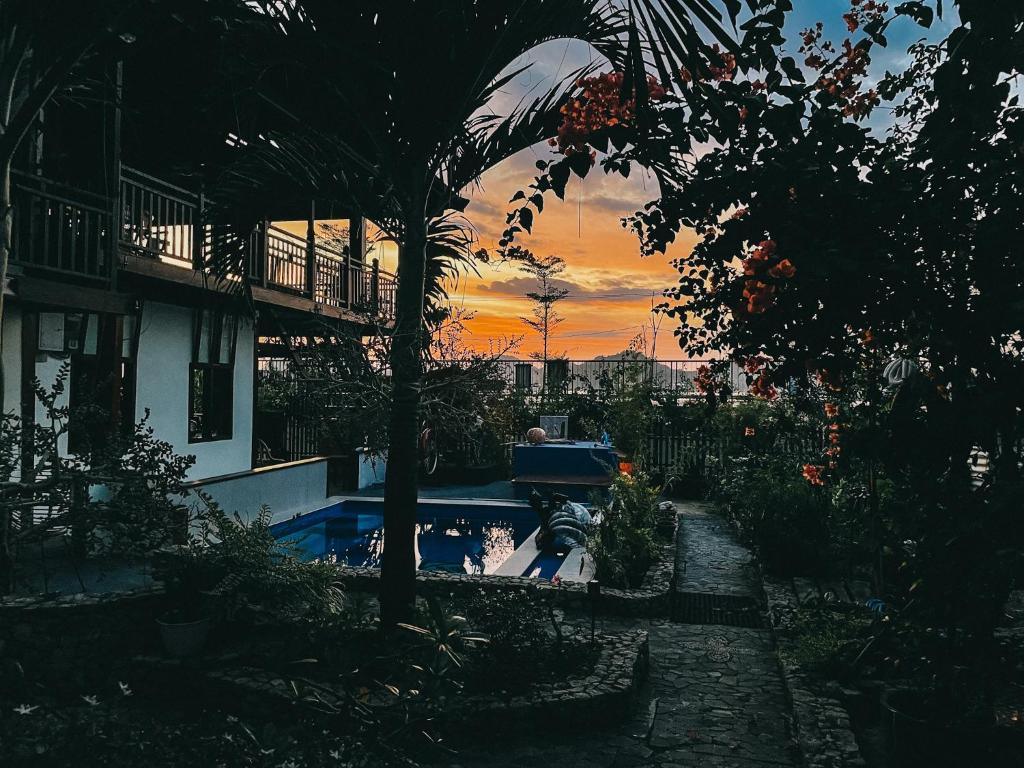 einen Pool vor einem Haus mit Sonnenuntergang in der Unterkunft Cool Breeze Authentic Hotel Labuan Bajo Komodo in Labuan Bajo