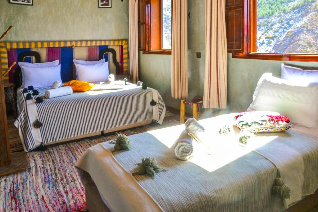 a bedroom with two beds and a window at Room in Lodge - Authentic and pittoresque room for 3 people in Tamatert, Morocco num1 in Tamatert