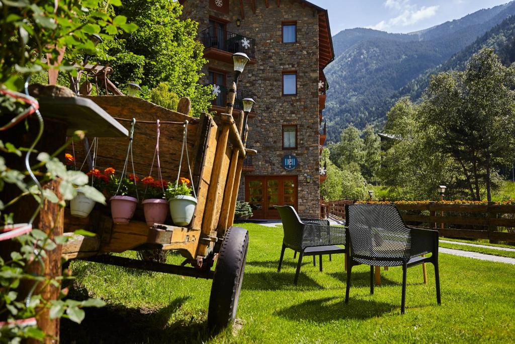 dwa krzesła i stół i krzesła na dziedzińcu w obiekcie Apartaments La Neu w mieście Ordino