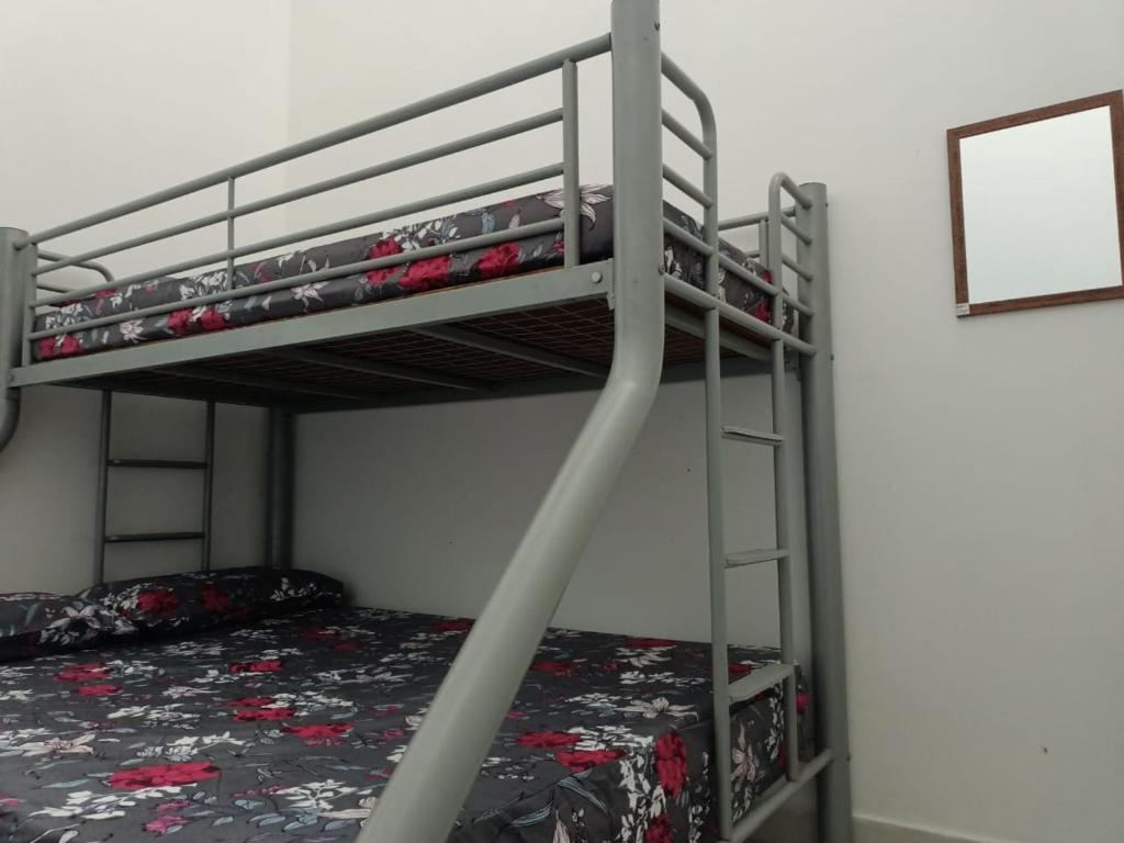 a bunk bed with a ladder next to a bunk bed gmaxwell gmaxwell gmaxwell at Two Bed Rooms -Cahaya Homestay Tanjung Malim in Ulu Bernam