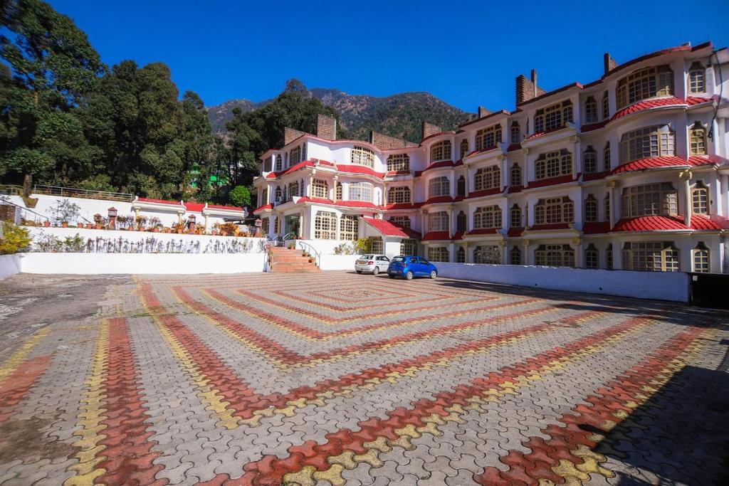ein großes Gebäude mit farbenfrohem Gehweg davor in der Unterkunft Royal Palace Resort Bhagsunag in Dharamshala