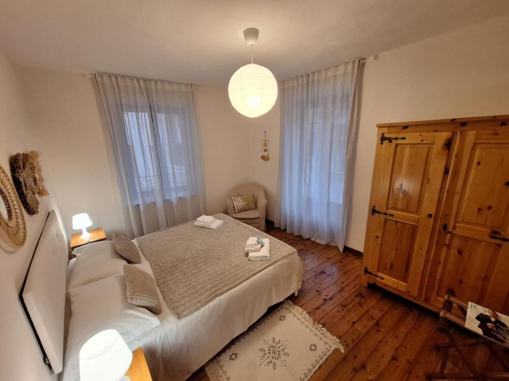 a bedroom with a large bed and a large window at La casa di Nonno Renzo in Acceglio
