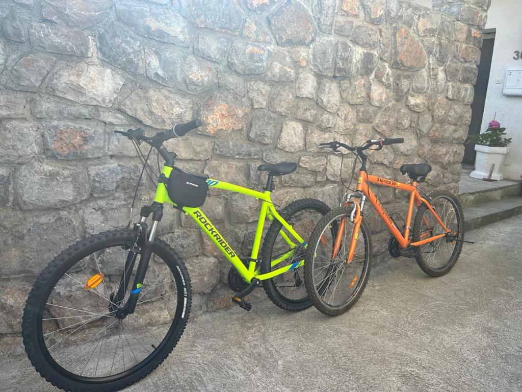 two bikes are parked next to a stone wall at Rooms Verda in Senj