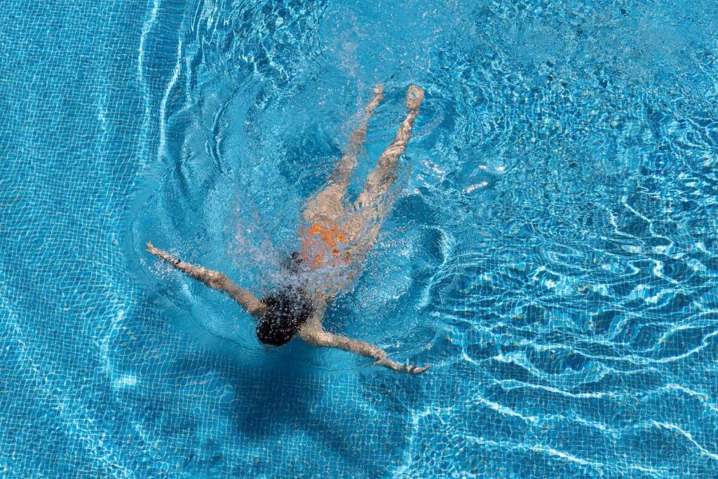 a person floating in a pool of water at Doria Hotel Bodrum-City Center in Bitez