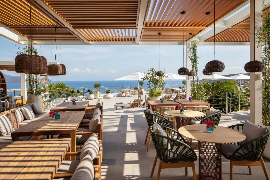 a restaurant with tables and chairs and a view of the ocean at Doria Hotel Bodrum-City Center in Bitez