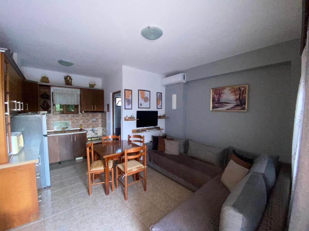 a kitchen and a living room with a couch and a table at Vila Tani in Ksamil