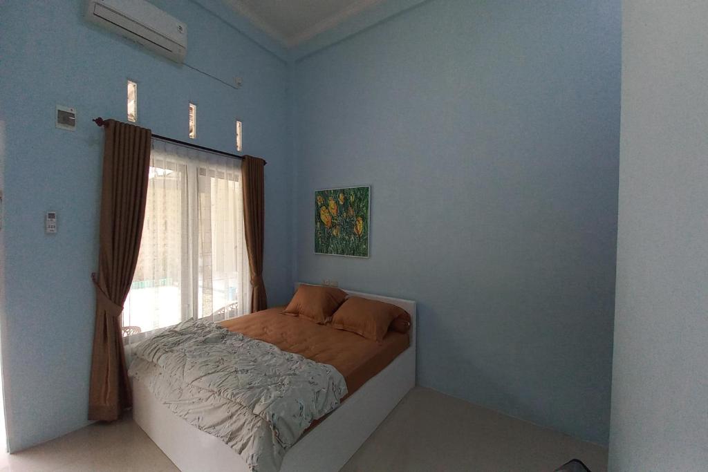 sypialnia z łóżkiem i oknem w obiekcie OYO 92701 Jasmine House Syariah w mieście Pekanbaru