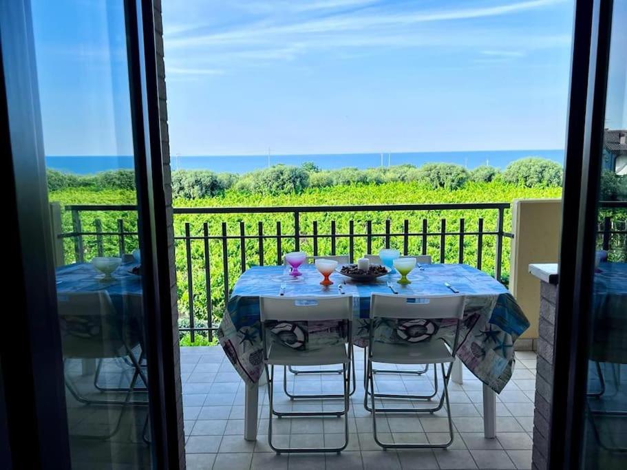 Una mesa en un balcón con vista al mar. en Appartamento Ortona Vista Mare, en Francavilla al Mare