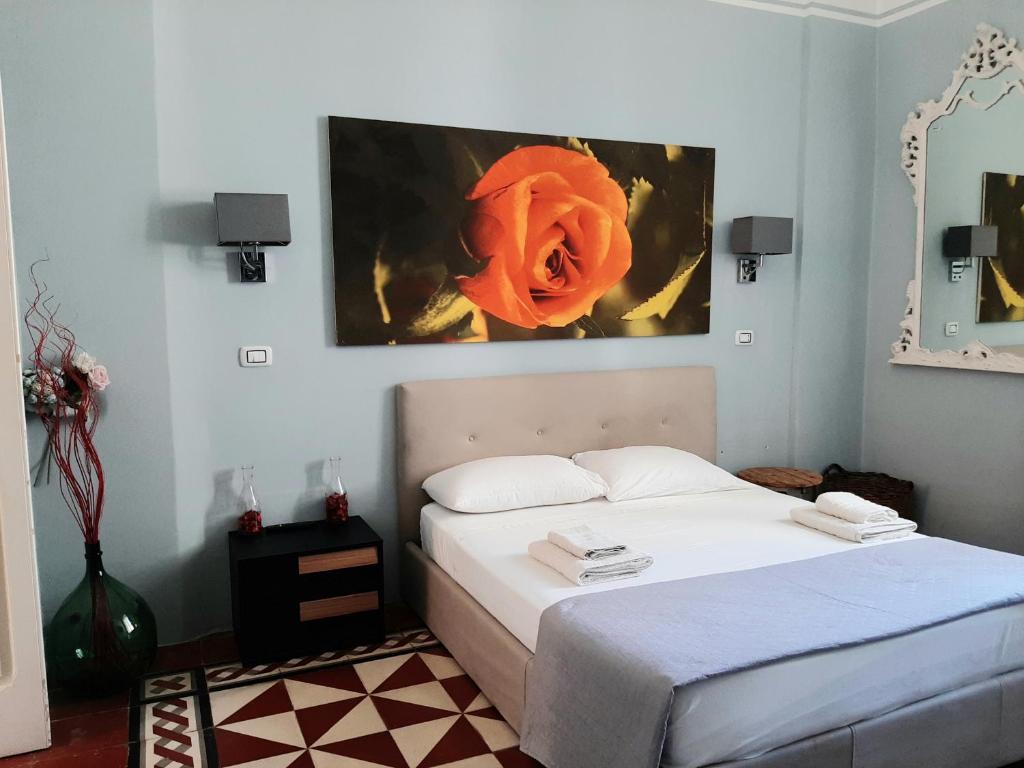 una camera da letto con un letto e un dipinto sul muro di Dimora " Le Rose " a Lecce