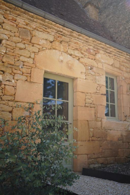 a stone building with a door and a window at Maison Lou Piade in Sarlat-la-Canéda
