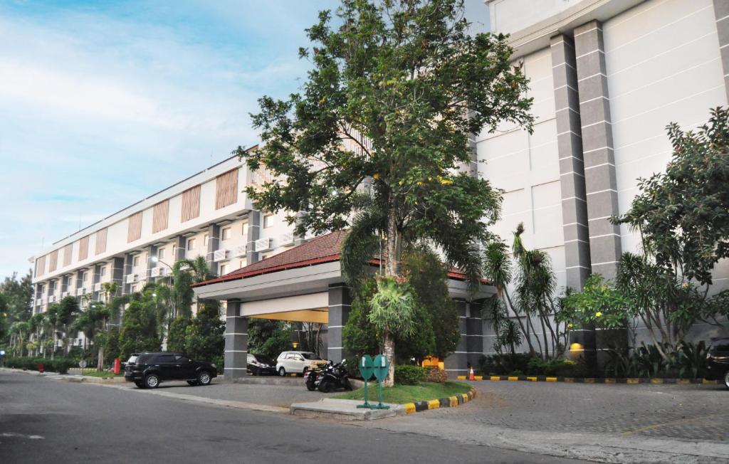 a building with a car parked in front of it at Lorin Dwangsa Solo Hotel in Solo