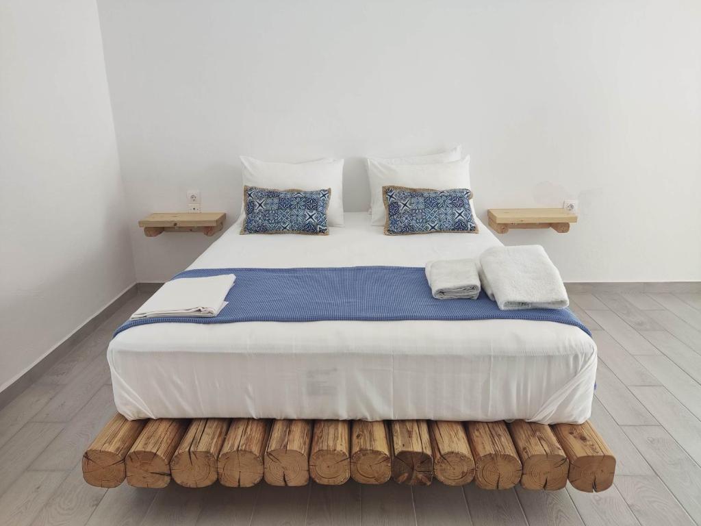 a bedroom with a large bed with blue pillows at Agnanti Hotel in Adamantas