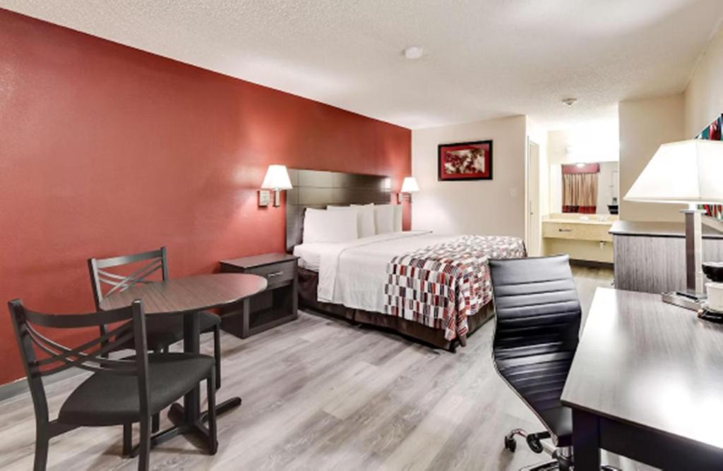 a hotel room with a bed and a table and chairs at American Inn in Corsicana