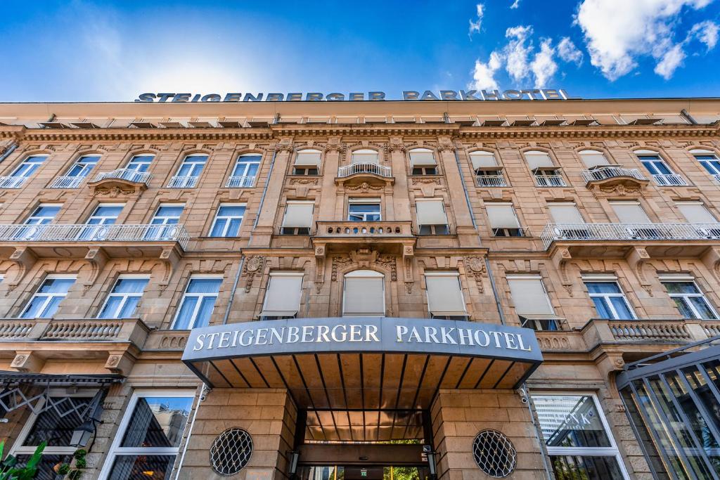 un edificio con un cartel en la parte delantera en Steigenberger Icon Parkhotel Düsseldorf, en Düsseldorf