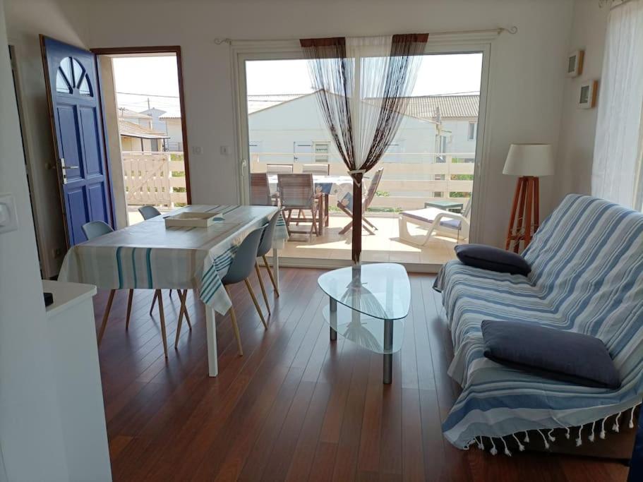 una sala de estar con un sofá y una mesa en Chalet La Mer Veille 1, en Gruissan