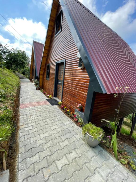 a brick path next to a building with a red roof at Kaşüstü Bungalov in Yomra