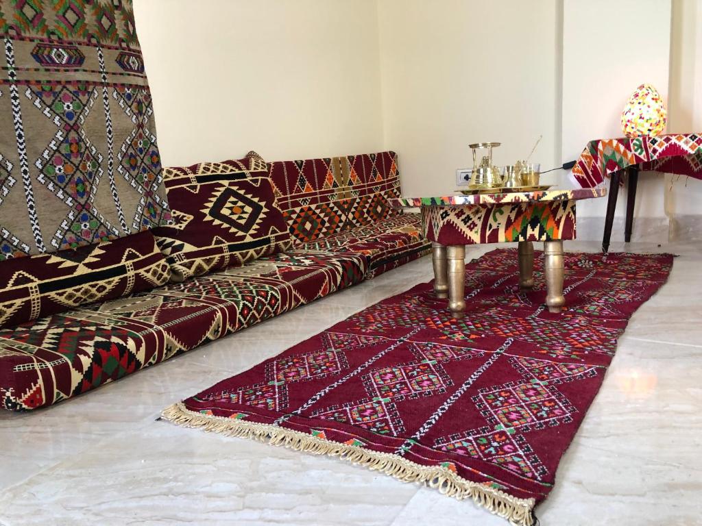 een woonkamer met een bank en een tafel op een tapijt bij Beduin Apartment with smart TV in downtown Cairo in Caïro