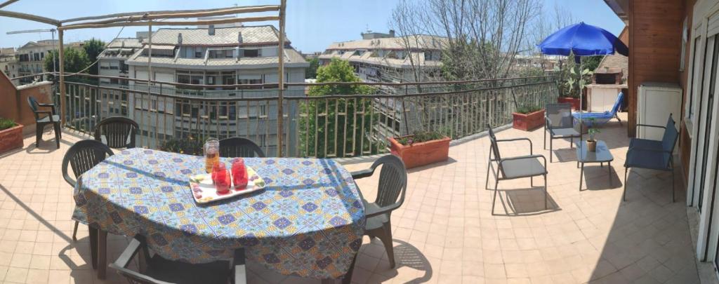 d'une table et de chaises sur un balcon avec une table et un parasol dans l'établissement Attico Centrale Ostia 20, à Lido di Ostia