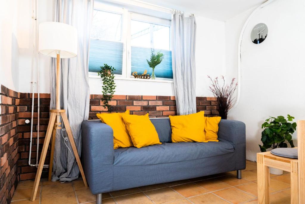 ein blaues Sofa im Wohnzimmer mit gelben Kissen in der Unterkunft Spacious Apartment in urban location in Hamburg