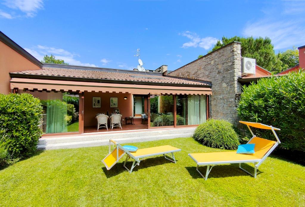 索亞諾德拉戈的住宿－Villetta Golf Holidays，一个带两把椅子的院子和一座房子