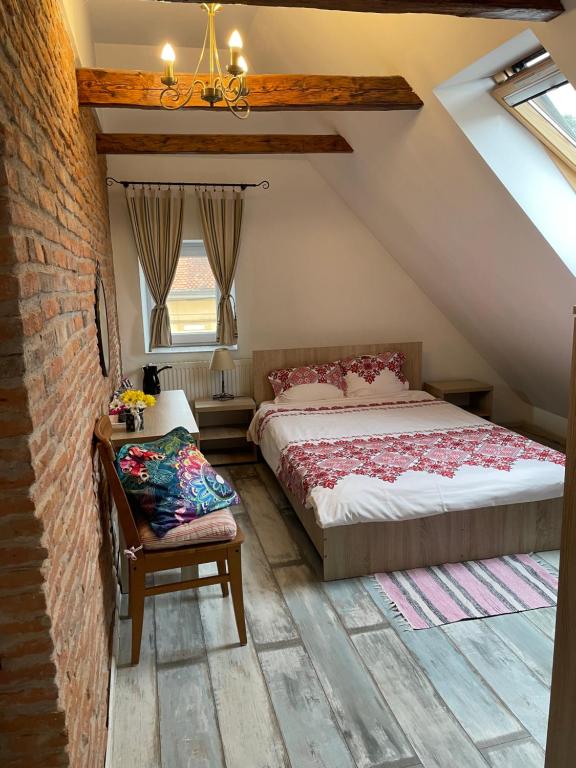 a attic bedroom with two beds and a chair at Blue House in Braşov