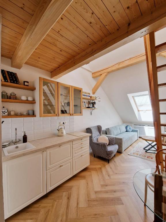 a kitchen with a sink and a living room at Apartmán Singer in Banská Štiavnica