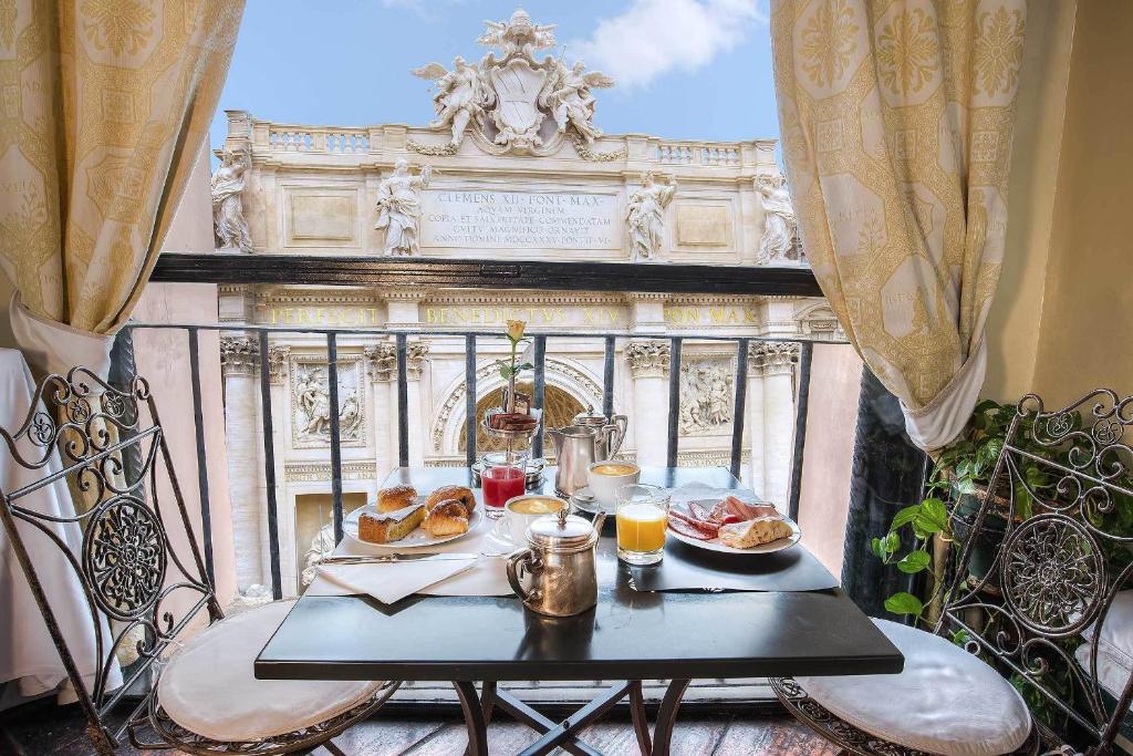 een tafel met eten op een balkon met uitzicht op een gebouw bij Hotel Fontana in Rome