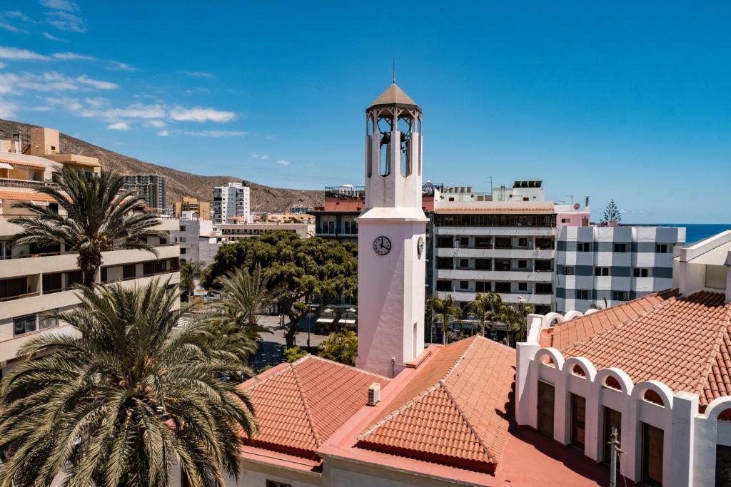a building with a clock tower in a city at Charming Apartment with Balcony - Heart of Los Cristianos in Arona