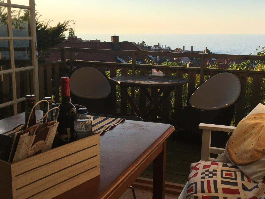 een tafel met een fles wijn op een balkon bij SPECTACULAR PANORAMIC VIEWS OF GUDHJEM in Gudhjem