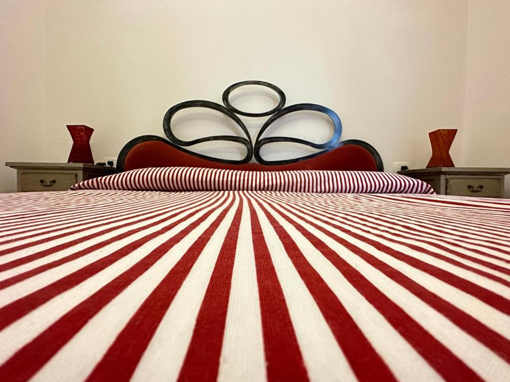 a bed with a red and white striped comforter at Baglio Mazzara in Custonaci