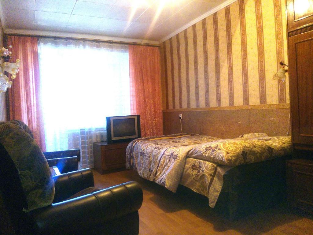 ムィコラーイウにあるApartments in the Centerのベッドルーム1室(ベッド1台、椅子、窓付)