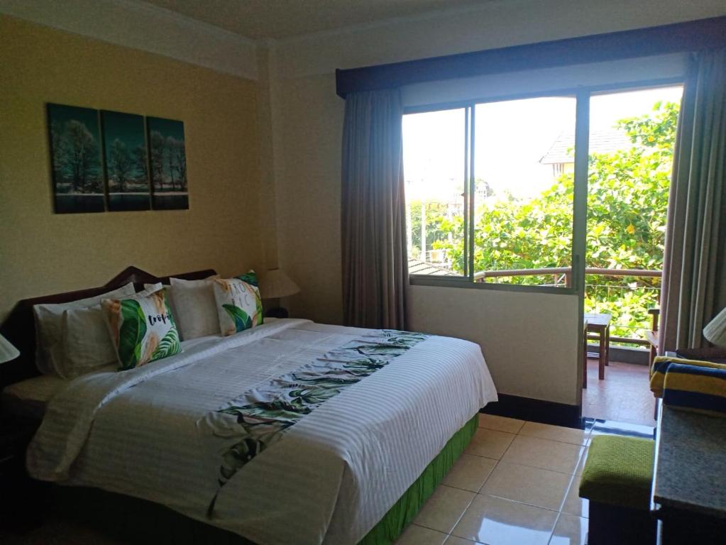 a bedroom with a bed and a large window at Kun's Stay Private Apartments in Seminyak